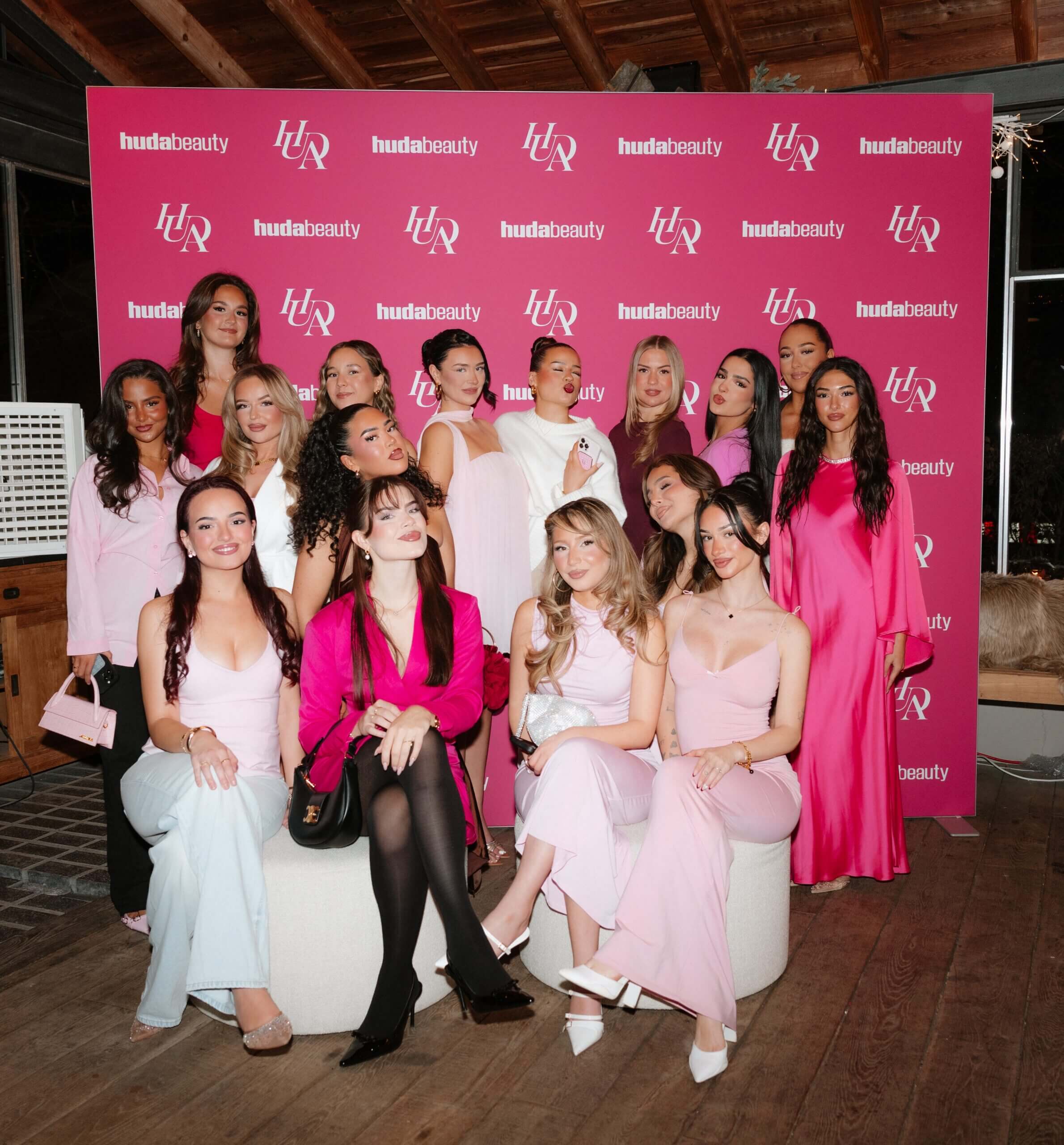 Huda Beauty Creator:innen vor einer pinken Fotowand bei der Easy Staycation