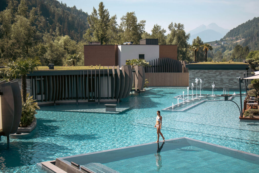 Poollandschaft der Quellenhof See Lodge in Südtirol mit Blick auf die Berge