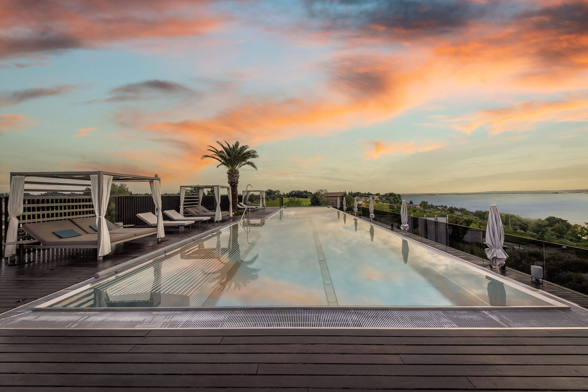 Infinitypool des Quellenhof Luxury Resort Lazise bei Sonnenuntergang mit Blick auf den Gardasee