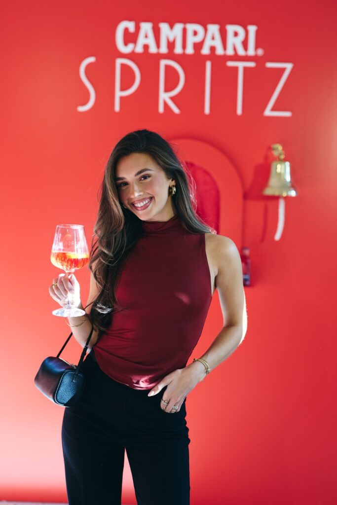 Gast mit Campari Spritz vor einer roten Campari-Fotowand