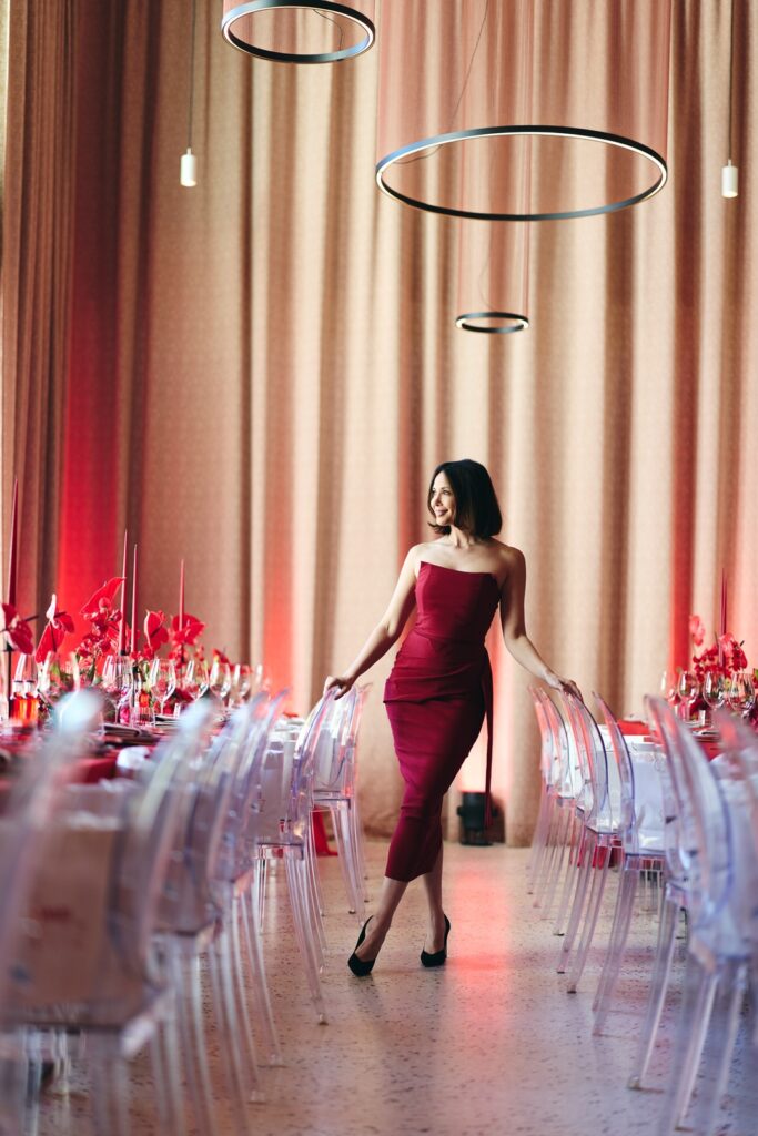 Frau in rotem Kleid zwischen den gedeckten Tafeln des Campari-Events